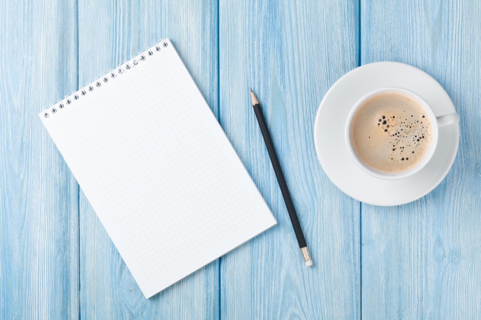 Coffee cup and blank notepad